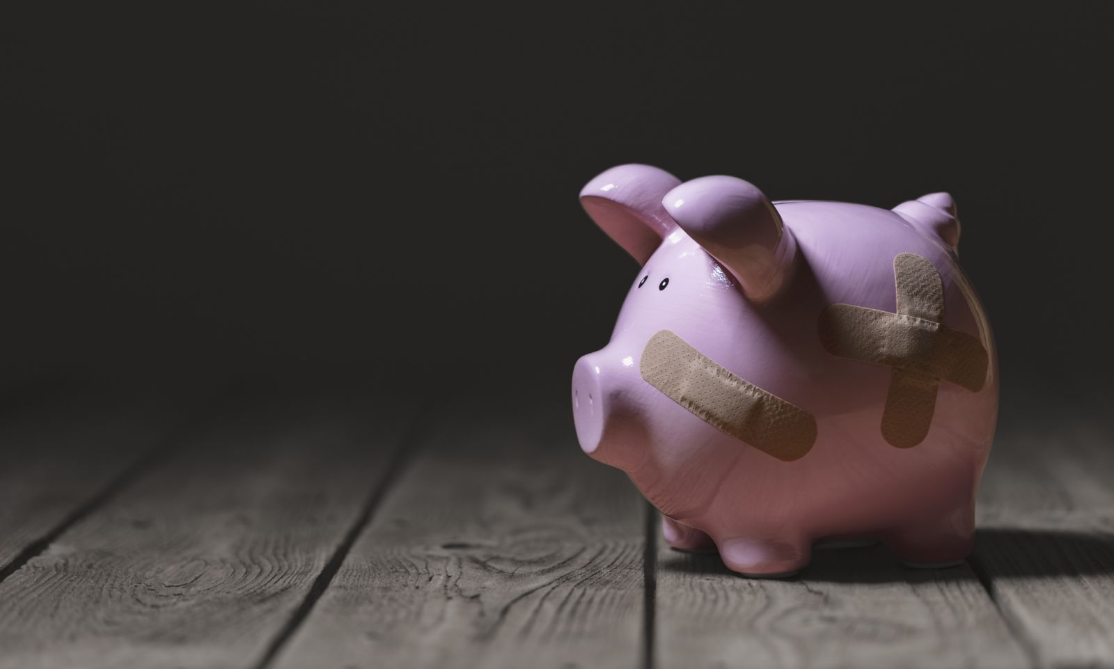 Piggy bank patched up with sticking plasters banner image