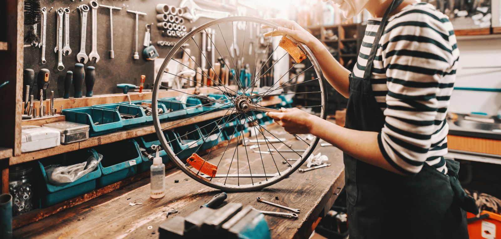 Woman making repairs to bicycle tyre banner image