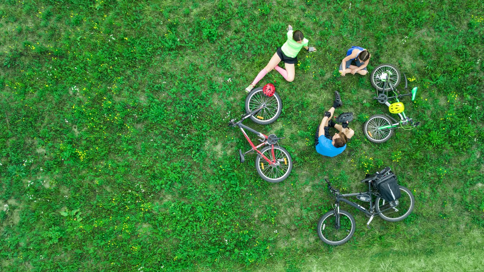 aerial view of cyclists relaxing on the grass banner image