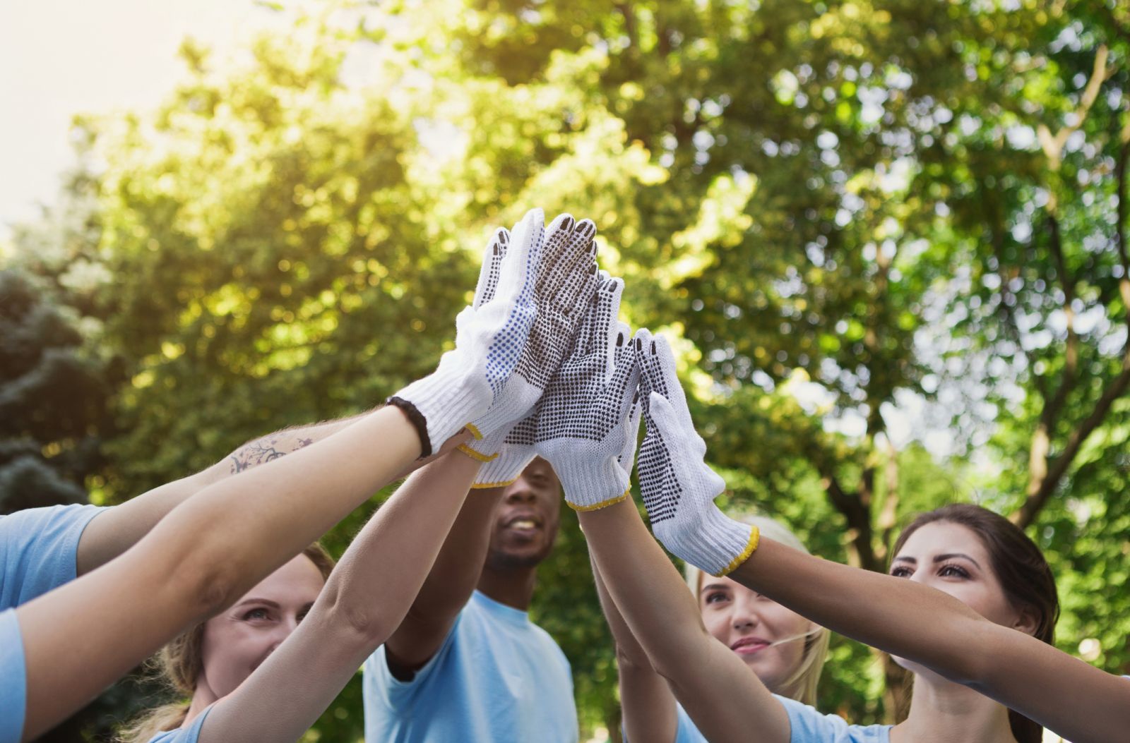 Group of people putting hands in the air together banner image