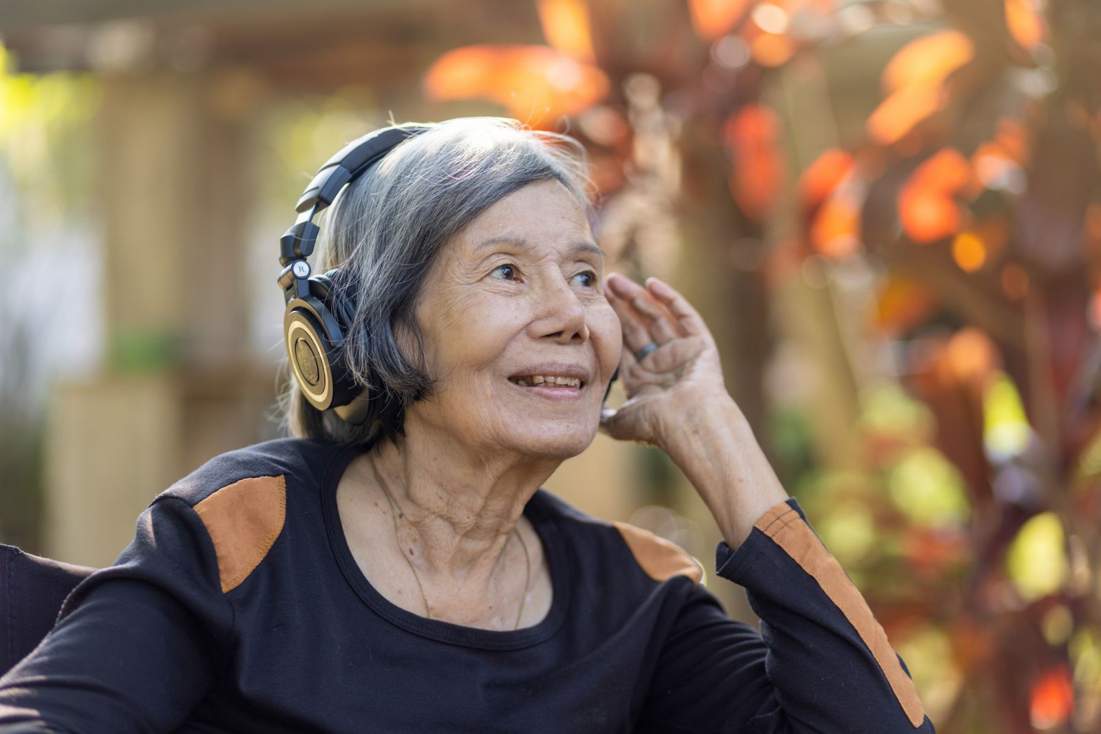 Older woman listening to music on headphones banner image